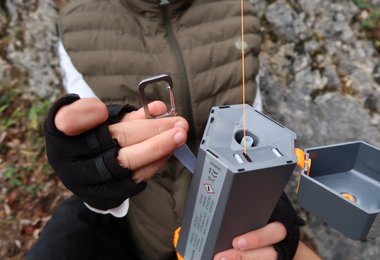 Mit dem Karabiner kann der AirMarker am Rucksack oder am Gurt fixiert werden.